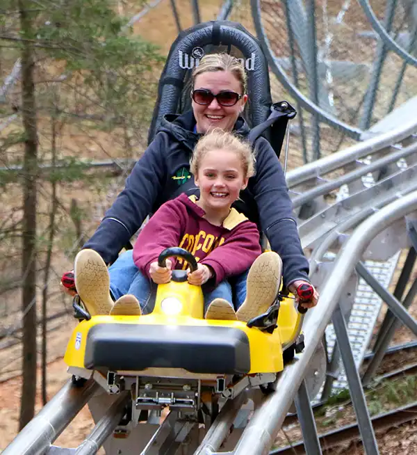 Woman and Child riding the hillside roller coaster in Helen GA