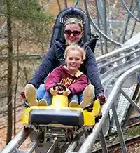 mother with daughter in front of her riding the hillside roller coaster in Helen Georgia